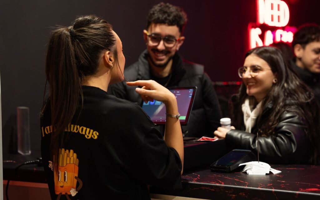 Empleado de Delirio atendiendo a clientes con una sonrisa en el restaurante