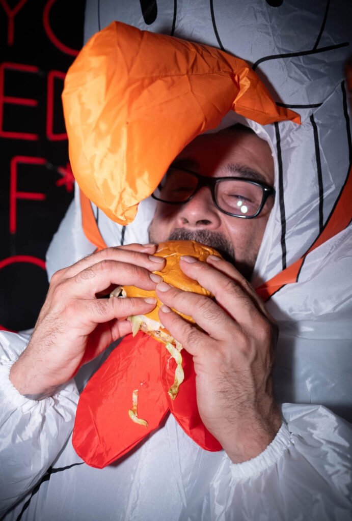 Hombre disfrazado disfrutando de una hamburguesa de Delirio Smash Burger